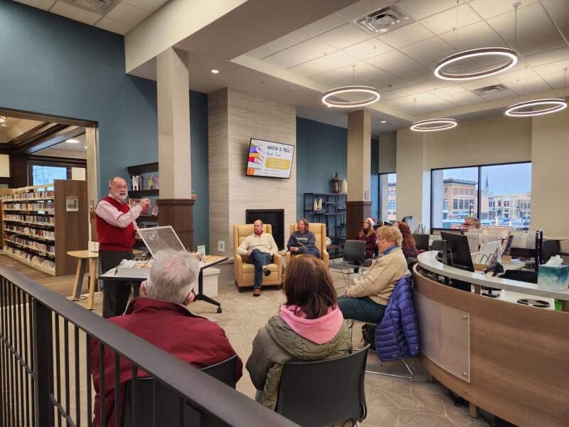 Man presenting vintage christmas decorations to a group