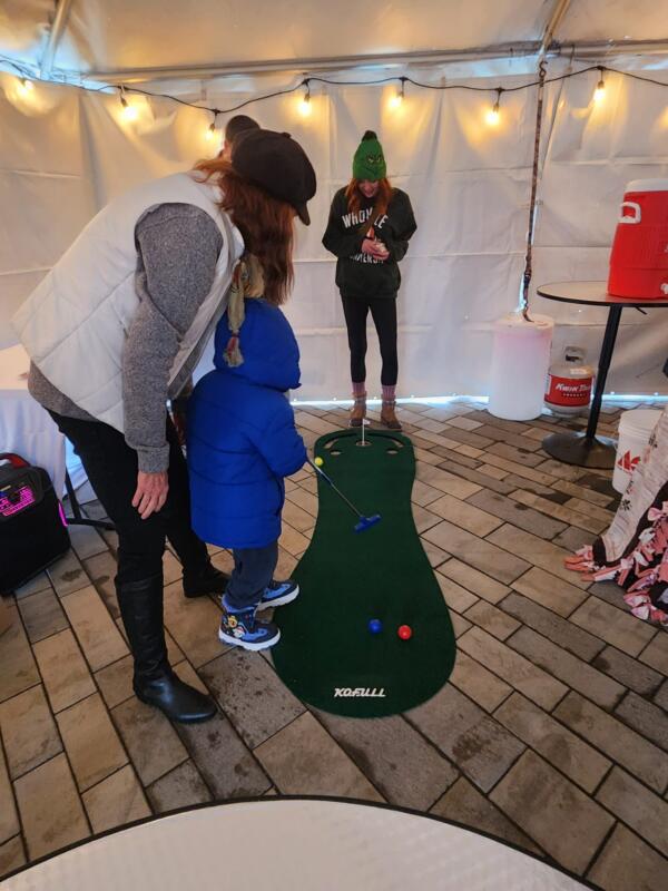 Kid putting on an indoor golf game