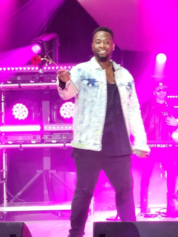 Man on stage with a rose