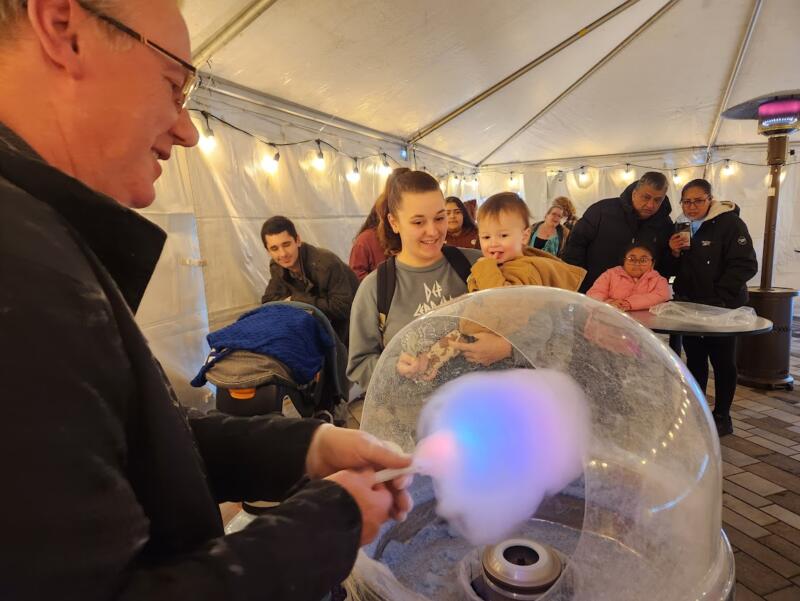 Cotton candy being made while a line of people wait at Jingle Bell on the Rock in Watertown wi