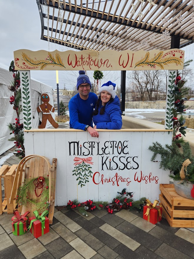 Couple in mistletoe photo booth at Jingle Bell on the Rock in Watertown Wi