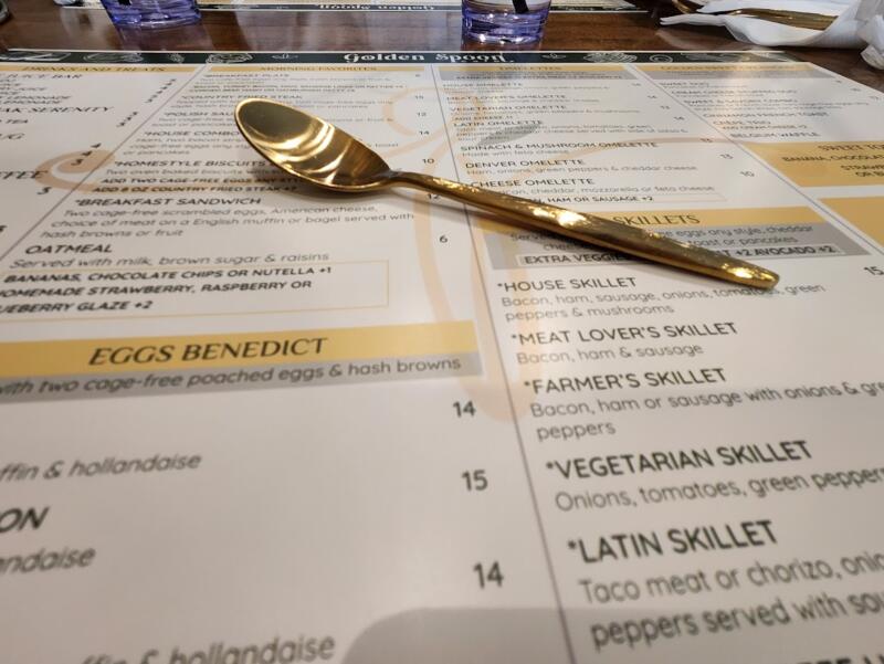 menu at The Golden Spoon with a gold spoon resting on top from The Golden Spoon in Watertown Wi