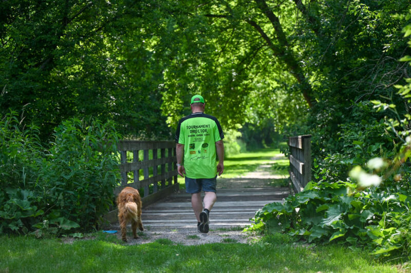 Man and dog walking across a bridge at Brandt-Quirk Park in Watertown Wi