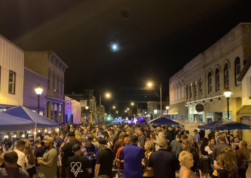 Large crowd listening to a band outdoors in downtown Watertown wi