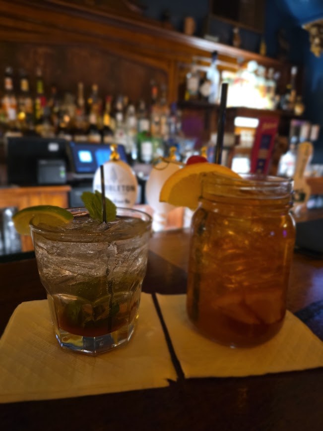 cocktails sitting on a bar with the background blurred