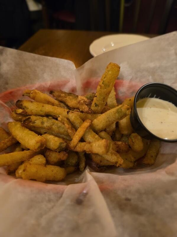 Fried pickles in a basket with dipping sauce